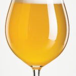 a golden colored pale ale beer with a white head and a slight haze to it in a stemmed tulip glass