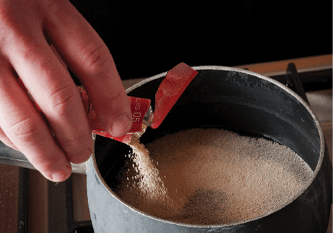 sprinkling a pack of dry yeast into water to rehydrate