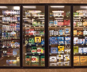 a grocery store cooler stocked with beer of various sizes