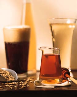 Glass of beer next to honey.