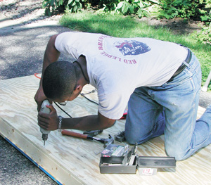 Man drills holes in plywood.