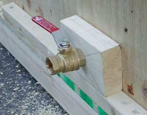 Brass fitting inserted into wood with a port valve.