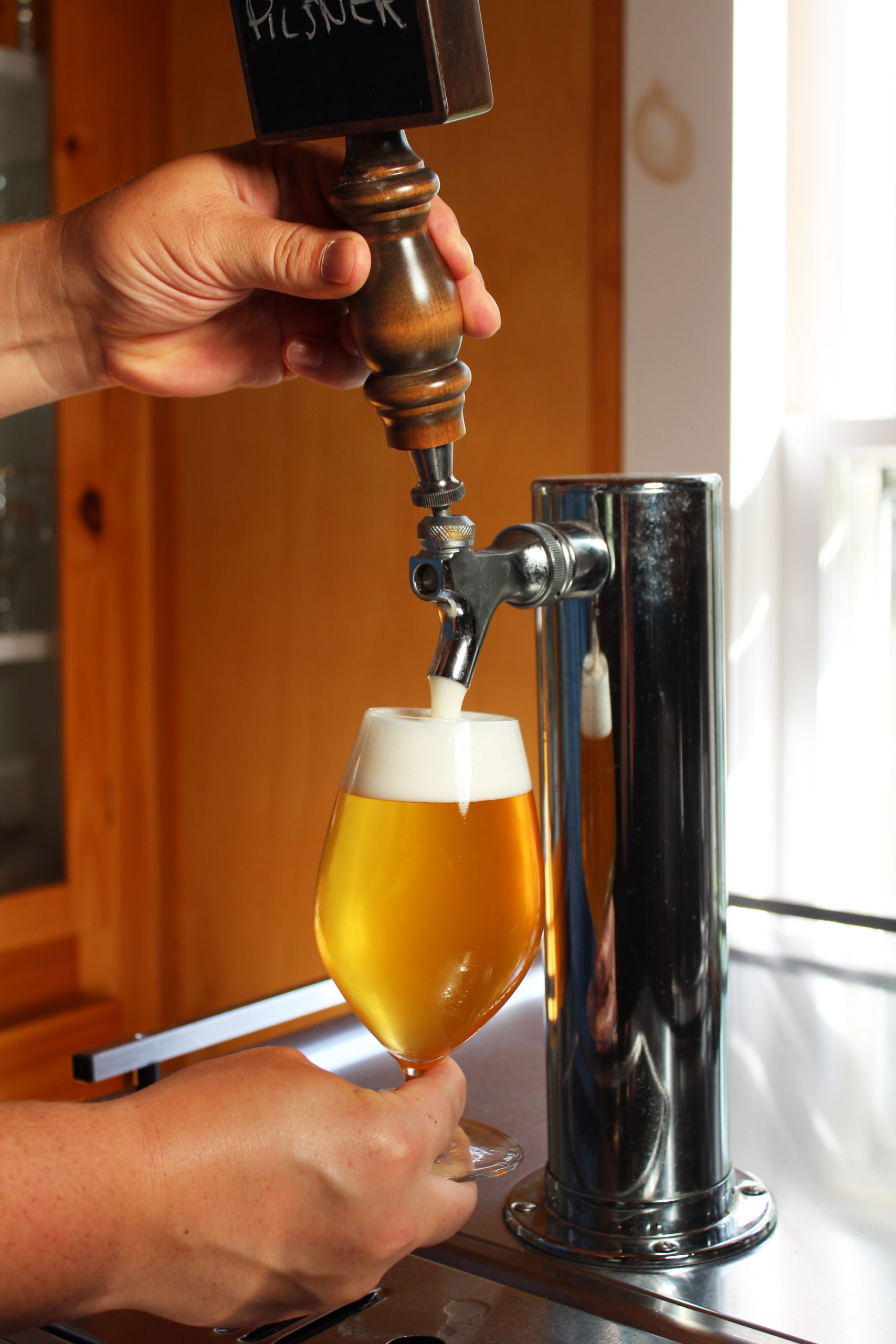 pouring beer from a stainless faucet